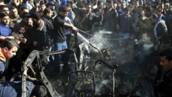 فلسطينيون في موقع الغارة التي استهدفت السيارة الخميس في غزة