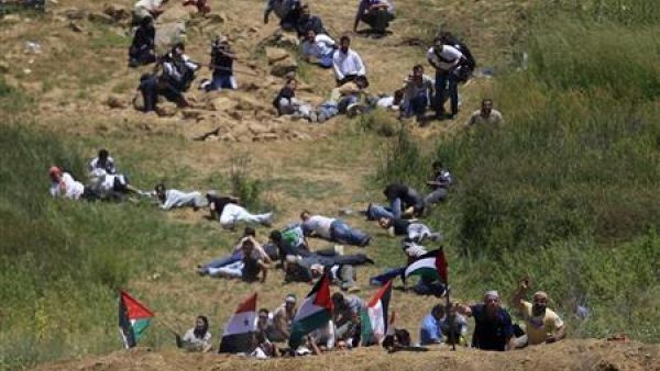 محتجون يحتمون خلال مظاهرة على الحدود الاسرائيلية السورية قرب قرية مجدل شمس في مرتفعات الجولان
