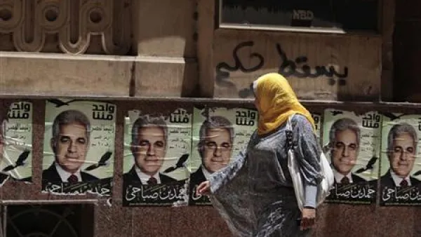 امرأة تمر بجوار ملصقات حمدين صباحي احد مرشحي الانتخابات الرئاسية المصرية