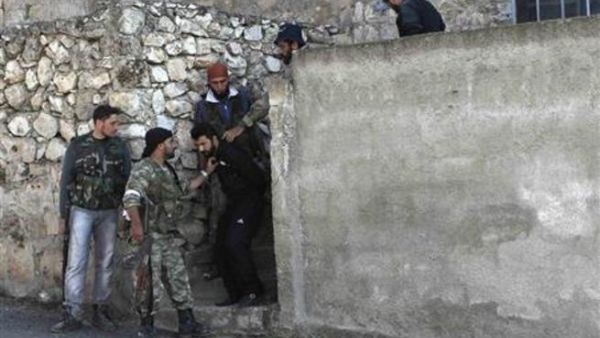 جنود من الجيش السوري الحر يأسرون رجلا يشتبهون في انتمائه لقوات الاسد في بلدة حارم
