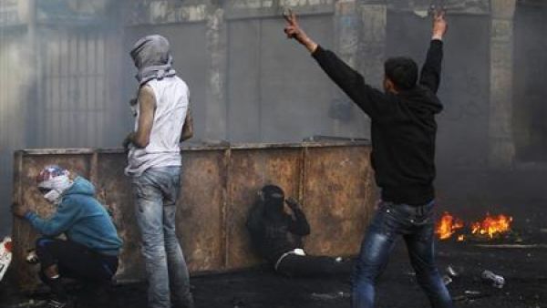  فلسطيني يلوح بعلامة النصر خلال اشتباكات مع جنود اسرائيليين في الخليل
