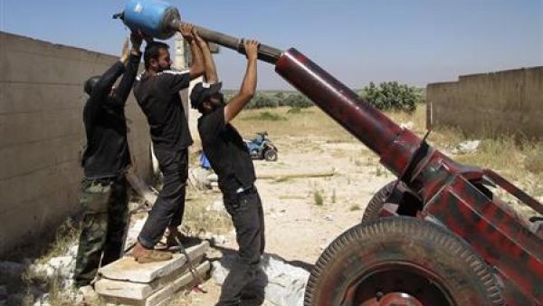 مقاتلون من الجيش السوري الحر يعدون قذيفة مورتر خلال هجوم على قوات موالية للاسد في إدلب