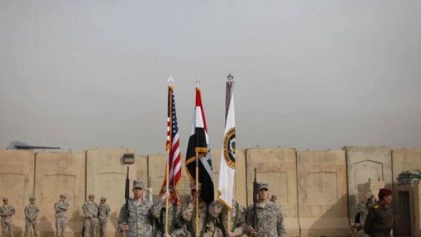 حمل العلم العراقي والاميركي وعلم والقوات الاميركية خلال مراسم انسحاب القوات الاميركية من العراق
