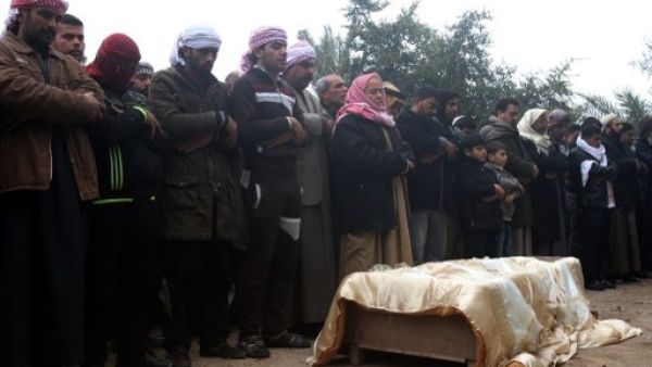 A family gathers to pray over the body of one of their relatives who was killed this weekend in clashes in Fallujah (AFP)