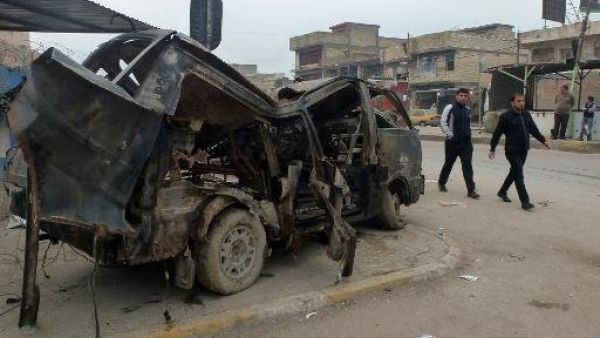 رجال عراقيون يسيرون الى جانب حافلة دمرها تفجير سيارة مفخخة في مدينة الصدر في بغداد
