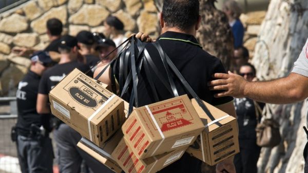 ISRAEL, Haifa : An Israeli man carries gas mask kits as he leaves a distribution center in the Mediterranean coastal city of Haifa, north of Israel, on August 29, 2013. AFP PHOTO / JACK GUEZ