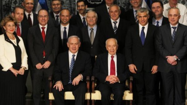 Israeli President Shimon Peres (C-R, seated) sits next to Prime Minister Benjamin Netanyahu (C-L, seated) as they pose for a group photo with the ministers of the new Israeli government in Jerusalem on Monday. (Photo: AFP PHOTO/POOL/RONEN ZVULUN) 