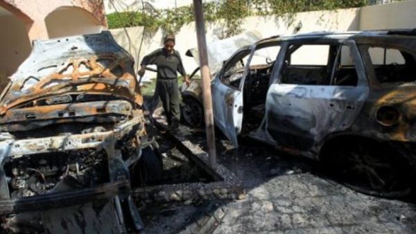 صبي فلسطيني يتفقد سيارات مدمرة امام منزل في غزة بعد غارة اسرائيلية
