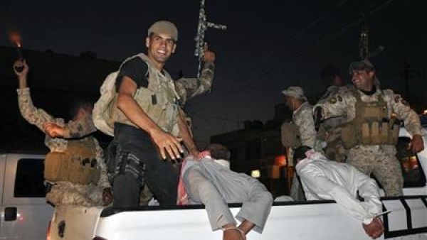 أفراد من قوات الأمن العراقية يحتفلون باعتقال بعض المتمردين في كربلاء