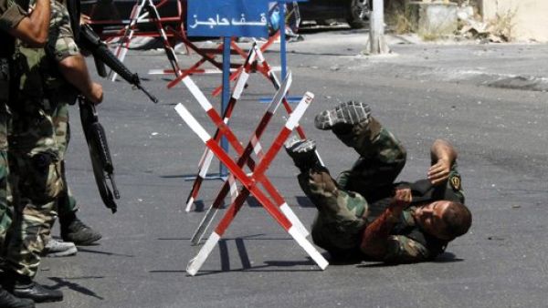 جنود لبنانيون يهرعون لنجدة زميل لهم اصيب خلال الاشتباكات في صيدا الاحد