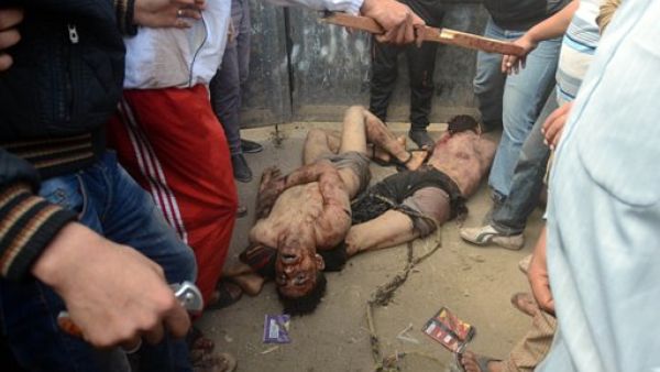 اهالي القرية يقفون قرب جثتي الرجلين