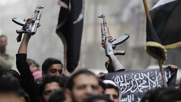 متظاهرون يرفعون اسلحة خلال احتجاج ضد الاسد في حلب