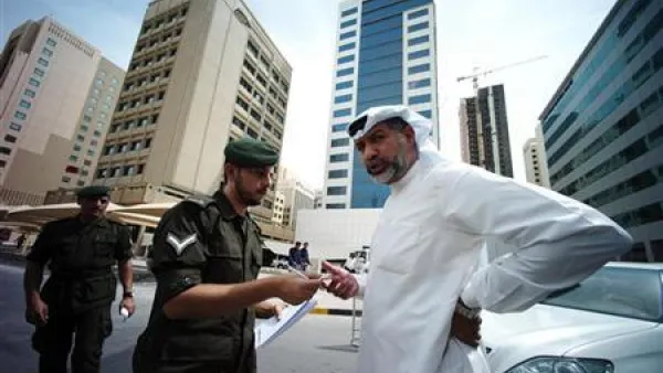 شرطي يتحقق من هوية رجل قبل دخوله لمحكمة في المنامة

