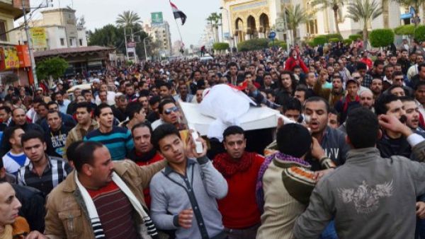 Egyptians carry the body of a person killed in overnight clashes between police and protesters in Egypt's Nile Delta city of Mansura, on Saturday. (Photo: AFP / STR)