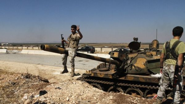 مقاتلون من الجيش الحر قرب دبابة استولوا عليها في مطار مينغ العسكري 