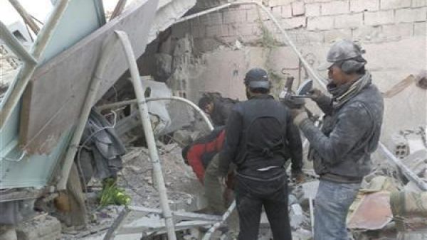 مقاتلون تابعون للجيش السوري الحر يبحثون عن جثث تحت الانقاض بعد غارة جوية على داريا بالقرب من دمشق

