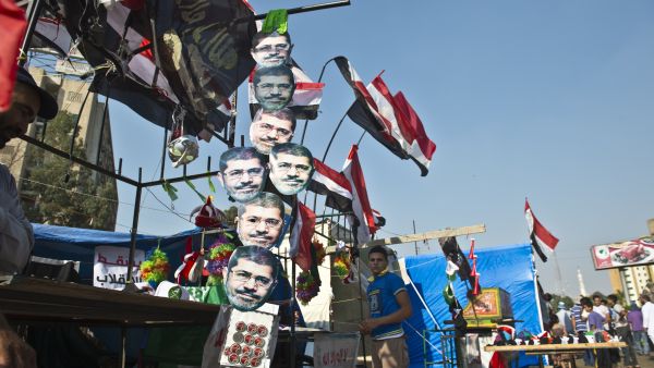 A young Egyptian street vendor sells national flags and masks of deposed president Mohamed Morsi outside Rabaa al-Adawiya mosque in Cairo (AFP/KHALED DESOUKI)