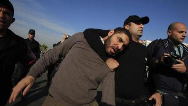 شرطي يعتقل احد مؤيدي الرئيس المصري المعزل محمد مرسي خارج قاعة محاكمته في القاهرة 