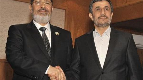 الرئيس المصري محمد مرسي (إلى اليسار) يصافح الرئيس الايراني احمدي نجاد في طهران يوم 30 اغسطس اب 2012
