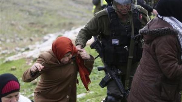 شرطي اسرائيلي يمنع ناريمان التميمي (الثانية من اليسار) من المشاركة في تظاهرة اسبوعية ضد المستوطنات 
