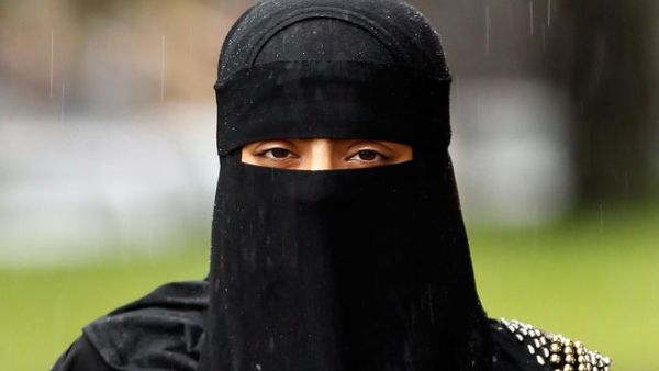 A woman wears a full face Niqab.