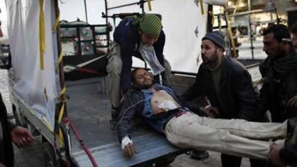 مقاتلون من الجيش السوري الحر يحملون زميلا لهم أصيب بالرصاص أثناء اشتباكات مع قوات موالية للأسد في حلب يوم الاثنين