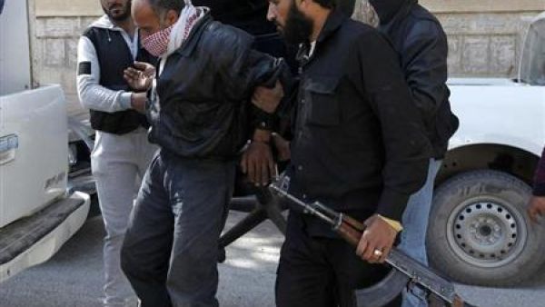 اعضاء في جماعة جبهة النصرة يقتادون معتقلا في شرق سوريا