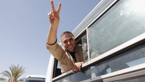 اسير محرر يشير بعلامة النصر من داخل احدى الحافلات التي اقلت الاسرى من اسرائيل