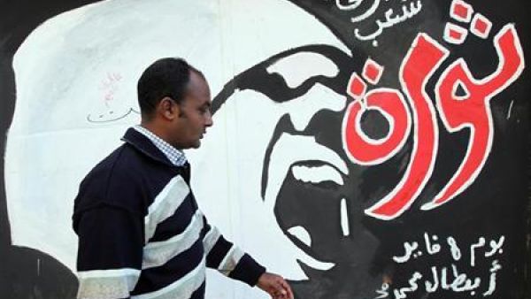 رجل يمر برسم عن الثورة على جدران في شارع محمد محمود قرب ميدان التحري