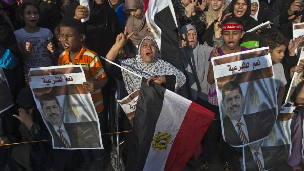Supporters of deposed Egyptian president Mohamed Morsi (portrait) cheer during a football match between the two main Cairo protest camps by members of the Muslim Brotherhood and backers of the ousted Islamist leader set up at the Nahda and Rabaa al-Adawiya squares (AFP/KHALED DESOUKI)