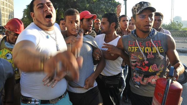 Pro-government and army supporters detain a supporter (C) of deposed Egyptian President Mohamed Mursi during clashes that erupted in Tahrir Square (AFP/FAYEZ NURELDINE)