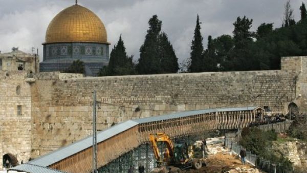 قبة الصخرة تبدو خلف حائط المبكى فيما تقوم جرافة بازالة ممر يؤدي الى باب المغاربة احد مداخل المسجد الاقصى 
