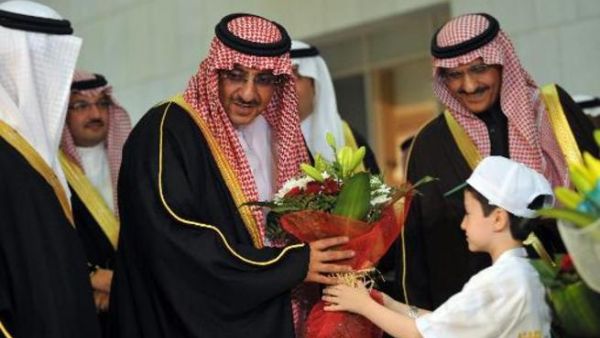 طفل سوري يقدم ورودا الى وزير الداخلية السعودي محمد بن نايف خلال افتتاح حملة التبرع للاطفال السعوديين في الرياض
