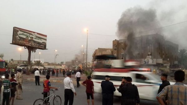 رجال شرطة ومواطنون عراقيون يتجمعون حول موقع انفجار في بغداد يوم الثلاثاء
