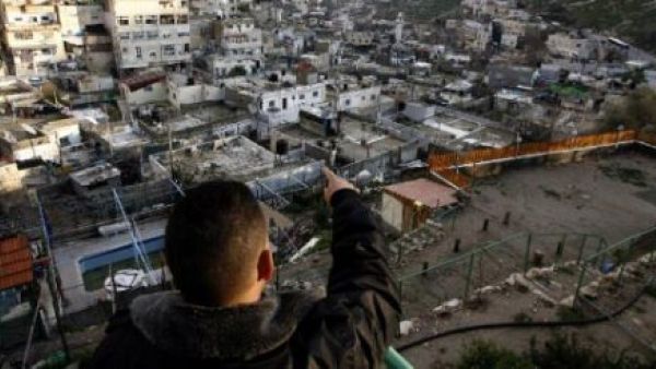 فلسطيني يشير إلى المخططات الاستيطانيّة في حي سلوان