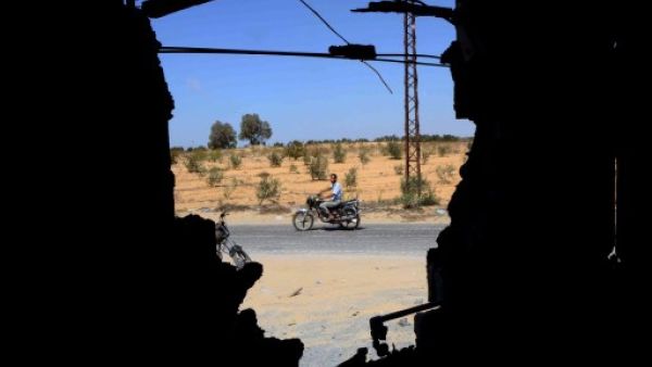 Four people died in a bomb that targeted an Egyptian intelligence facility in Sinai on Wednesday. Here, a man is seen riding his motorbike through a wall that was destroyed by an attack by Egyptian Army in the Sinai peninsula. (AFP)