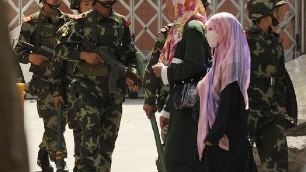 امرأتان من الاويغور تمران امام شرطة صينية في اورومتشي عاصمة شينجيانغ
