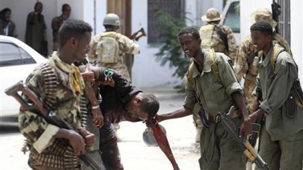جنود صوماليون يساعدون رجلا أصيب في انفجار في مقديشو يوم الأحد
