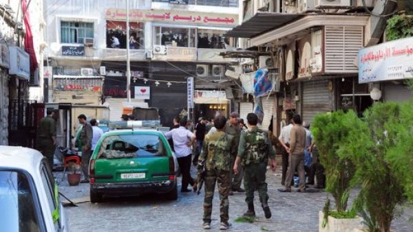 جنود سوريون يقفون قرب موقع احد الانفجارين