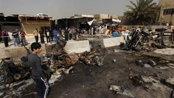 اشخاص يتجمعون في موقع هجوم بقنبلة في بغداد يوم 17 فبراير شباط 2013. 