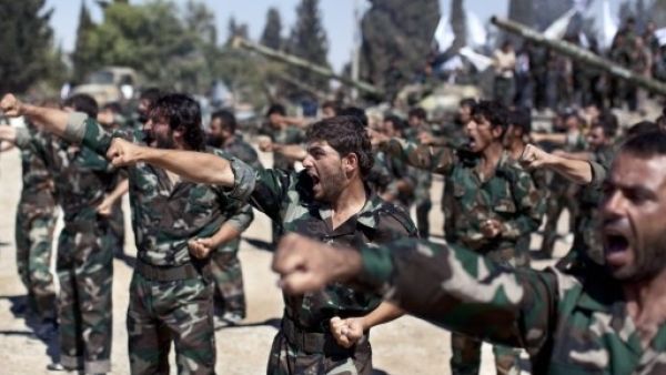 Members of rebel brigades parade at a former military academy north of Aleppo. Syrian rebels have expressed disdain for US President Barack Obama after he backed away from striking over alleged chemical weapons attacks, while saying the world doesn't really care about Syria. (AFP)