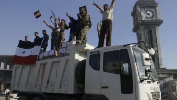 جنود من الجيش النظامي يحتفلون باستعادة القصير