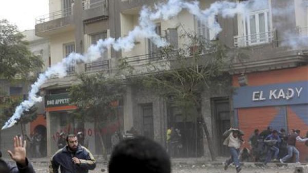 محتجون يهرعون فيما تطلق الشرطة الغاز المسيل للدموع قرب ميدان التحرير
