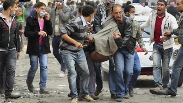 محتجون مصريون يحملون زميلا لهم أصيب في الاشتباكات بميدان التحرير
