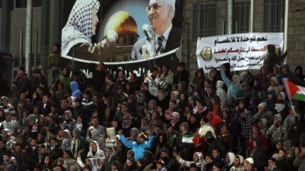 مشجعون يتابعون مباراة في كرة القدم بين منتخبي فلسطين وتايلاند في الرام
