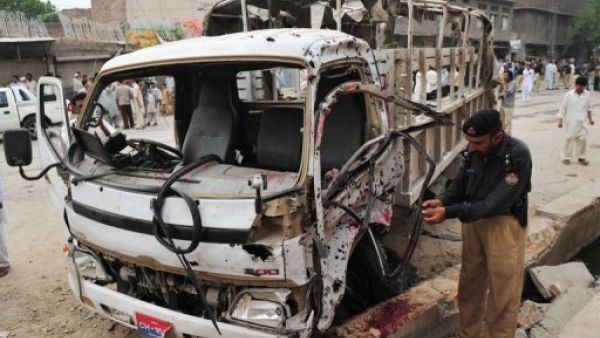 شرطي افغاني يتفقد شاحنة استهدفها اعتداء بالقنبلة في بيشاور 