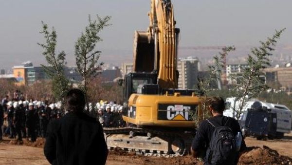 محتجون يتوجهون نحو الشرطة التركية وحفارة اثناء نقلها اشجارا في موقع بناء طريق في انقرة