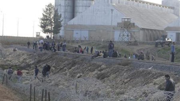 اشخاص يفرون بعدما قصفت مقاتلة تابعة للقوات الجوية السورية في راس العين على الحدود مع تركيا
