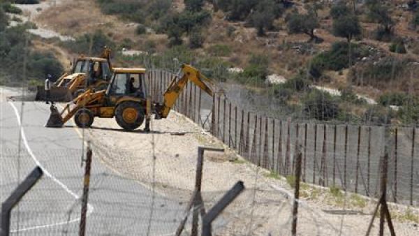 جرافات تزيل جزءا من الجدار العازل المثير للجدل قرب قرية بلعين في الضفة الغربية يوم الاحد
