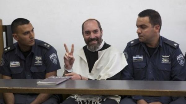 Israeli settler Yaakov Teitel flashes the "V" for victory sign prior to the start of his trial at the Jerusalem District Court on Tuesday. (Photo: AFP - Ahmad Gharabli)